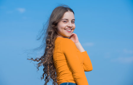 teen girl with cheerful face on sky backgroundの写真素材