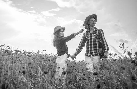 look there. couple in love. man with guitar and woman in poppy field.の写真素材