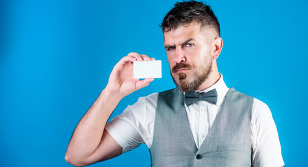 Keeping your company top of mind. Businessman with bank card. Bearded man holding business card. Hipster with credit card. Empty card for your contact information, copy spaceの写真素材