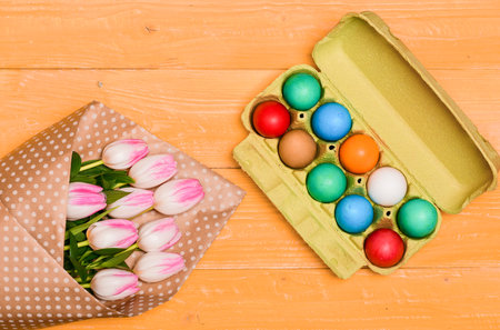 Egg hunt. Spring holiday. Holiday celebration, preparation. Tulip flower bouquet. Healthy and happy holiday. painted eggs in egg tray. Happy easterの写真素材