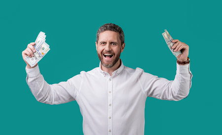 successful millionaire with money isolated on blue background. millionaire hold moneyの写真素材
