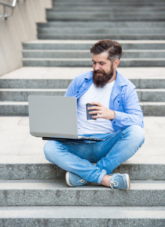 smiling man freelancer has video call outside. man freelancer has video call at coffee break.の写真素材