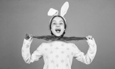 happy easter child girl in bunny rabbit ears and pajamas, easter holidayの写真素材