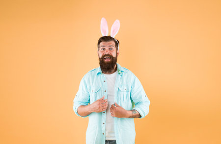 Always wear rabbit ears. Happy bunny rabbit yellow background. Bearded man wear rabbit costume. New life. Spring time. Rebirth and fertility. Holiday celebration. Easter days rabbitの写真素材