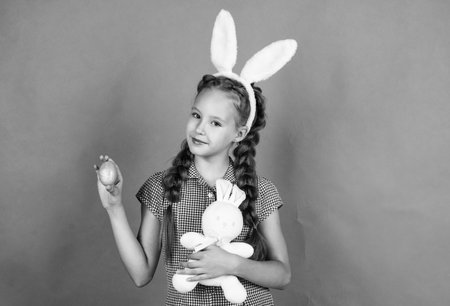 Delicious treats. happy girl holding easter hare toy. kid wear bunny ears. child in rabbit costume. spring holiday fun. happy easter. egg hunt began. childhood happiness. Getting ready for Easterの写真素材