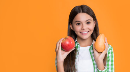 happy kid with apple and pear on yellow backgroundの写真素材