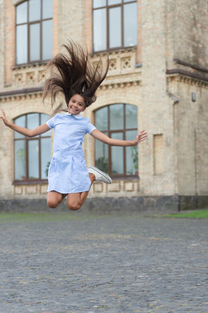 childhood happiness of glad teen girl outdoor. childhood happiness of teen girl jumping outsideの写真素材