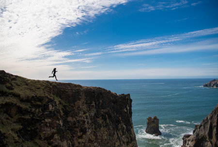 free woman runner running on the cliff. freedom and motivationの写真素材