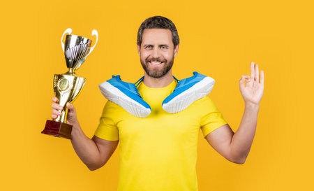 photo of champion man winner with sneakers, ok. champion man winner isolated on yellowの写真素材