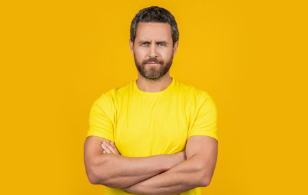 confident man wear tshirt in studio. photo of man wear tshirt. man wear tshirt isolated on yellowの写真素材