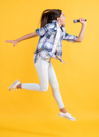 teen girl karaoke singer jumping in studio. teen girl karaoke singer on background.の写真素材