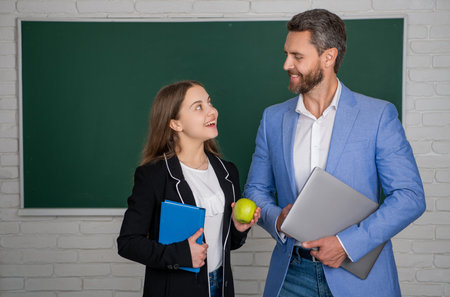 positive girl with man teacher in classroom. education