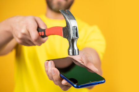 hack the phone screen in studio with closeup. photo of hack the phone screen with hammerの写真素材