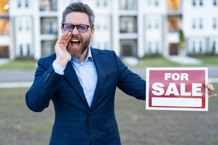 sale property by realtor shout outdoor. photo of realtor with for sale board. sale property