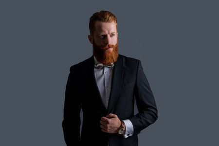 tux fashion. handsome bearded man in tux isolated on grey background. man studio shot in tux.の写真素材