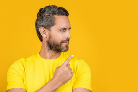 photo of cheerful man pointing at advertisement offer. man pointing at advertisement offerの写真素材