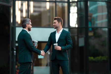 two business partners hold coffee dealing negotiation, copy space. photo of two business partnersの写真素材