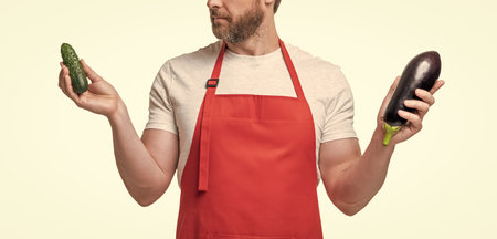 cropped view of man in apron with vegetables isolated on white.の写真素材