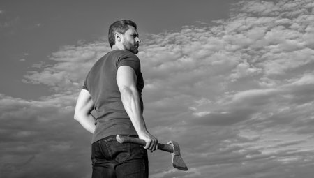 man with axe. woodcutter man hold ax. brutal man on sky background.