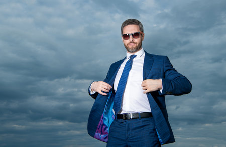 carefree business man in suit on sky background with copy space.の写真素材