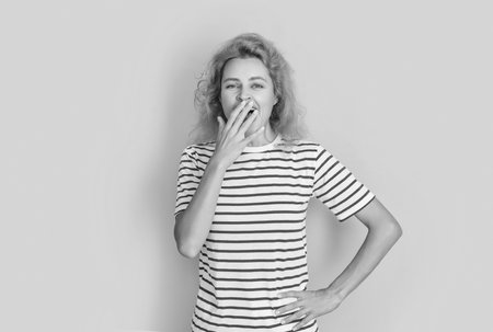 yawning redhead girl portrait isolated on yellow background. portrait of young redhead girl in studio. adult redhead girl portrait.の写真素材