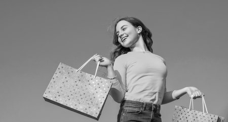 happy teen child with shopping bag, blue yellow.の写真素材