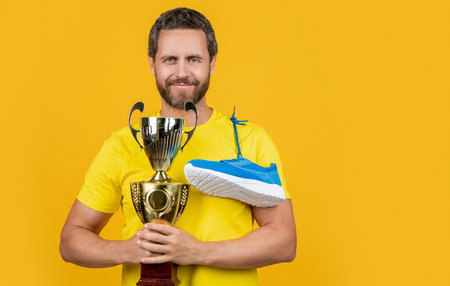champion man hold award isolated on yellow, copy space. champion man hold awardの写真素材