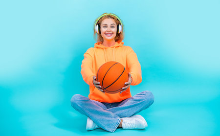 selective focus photo of basketball woman loves music isolated on blueの写真素材