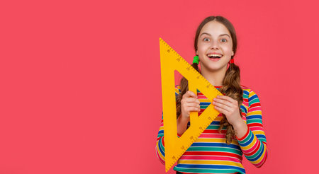 amazed school child hold math tool of triangleの写真素材