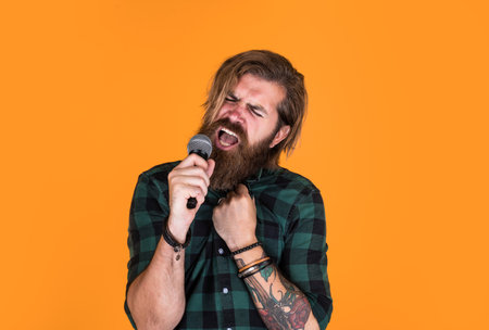 mature bearded man looking casual trendy singing in microphone, music.の写真素材