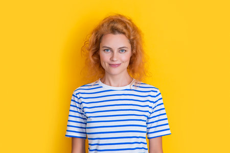 redhead girl smile isolated on yellow background. portrait of young redhead girl in studio.の写真素材