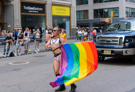 NEW YORK, NY, US - June 25, 2023: Pride march parade 2023 in New York. man gay with pride rainbow lgbtq flag peace. lgbt and lgbtq parade.のeditorial素材