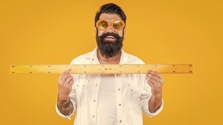 happy school man measure with ruler in studio. school man measure with rulerの写真素材