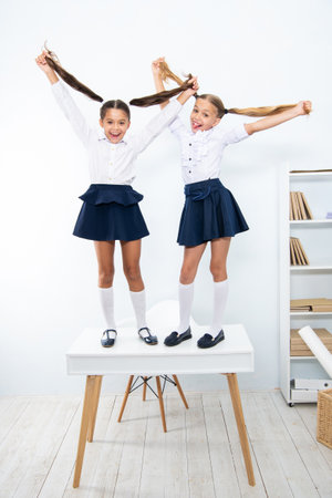 children girls wearing uniform of high school and having fun at the deskの写真素材