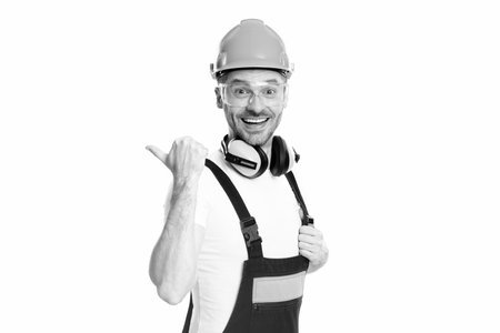 builder man wearing uniform pointing finger. photo of builder man. builder man isolated on white background. builder man in studio.の写真素材