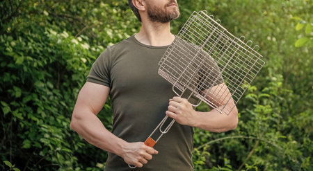 cropped view of man with barbecue grill. man with barbecue grill outdoor.