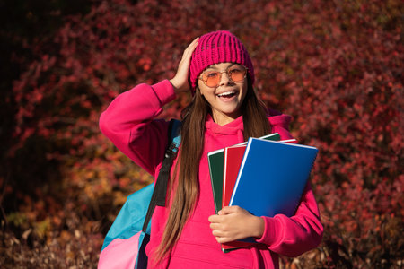 school knowledge. back to school. autumn girl holding school homework. knowledge for adolescence. teen girl in autumn park outdoor. autumn is a time to study. knowledge and education. school classesの写真素材