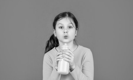 funny kid drink water on pink background.の写真素材