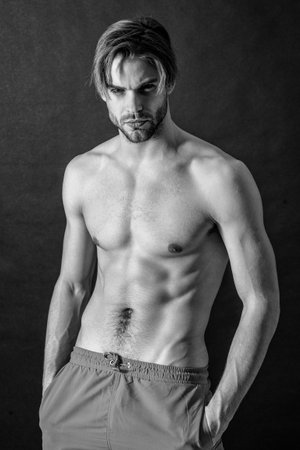 adult man with muscular abs in studio. muscular man with abs muscles. photo of man with muscular abs. muscular man with abs isolated on black background.の写真素材