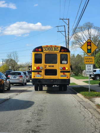 Chicago, USA - April 21, 2023: yellow school bus on the city road in traffic, back viewのeditorial素材