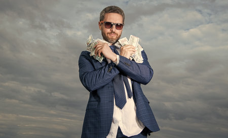 photo of billionaire man show money. billionaire man with money on sky background.の写真素材