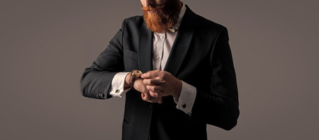 tuxedo fashion. punctual bearded man in tuxedo check time on watch isolated on grey background