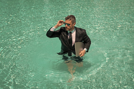 image of businessman has freelance business in pool. businessman has freelance business online.の写真素材