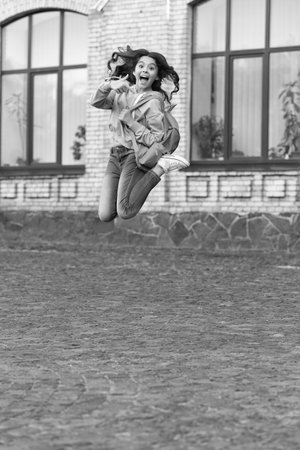 school girl jump childhood at the street, back to school. photo of school girl jump childhoodの写真素材