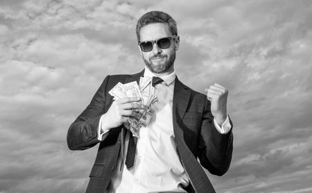 richness photo of successful man with money. richness of man with money on sky background. richness of man with money outdoor. richness of man with money in suit.の写真素材