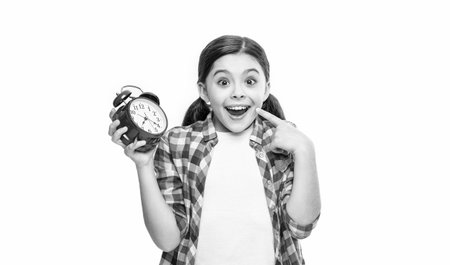surprised punctual teen girl with alarm on background. photo of punctual teen girl with alarm clock