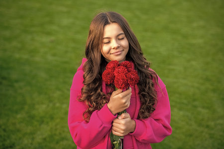 teenager girl smelling fall flowers outside. photo of teenager girl with fall flowersの写真素材