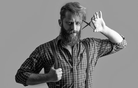 photo of hairstylist barber bearded man hold barbershop scissors. barber bearded man at barbershop...