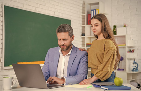 curious teen kid with man teacher in classroom. education.の写真素材