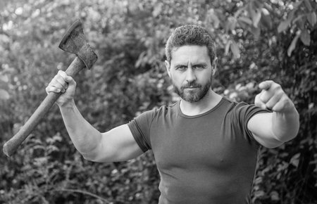 man threatening with hatchet wearing shirt, selective focus. man threatening with hatchet